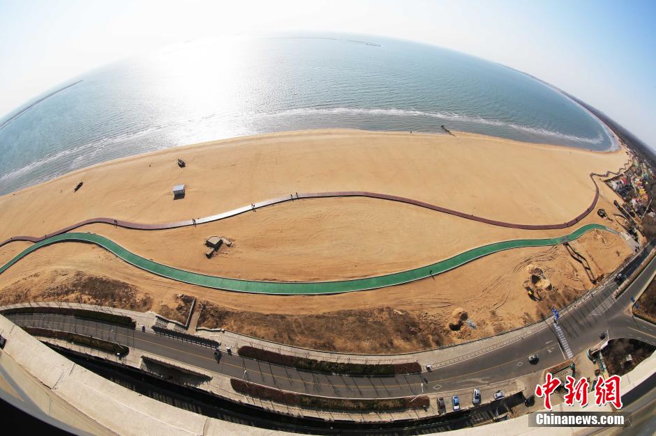 3月13日，秦皇島萬米臨海沙灘木棧道。據(jù)了解，該木棧道全長約4200米，與北戴河區(qū)原有的7500米木棧道對接后全線總長度1.17萬米，整個(gè)木棧道東起秦皇島體育基地游船碼頭，西至北戴河濕地公園，呈波浪形蜿蜒10.4公里海岸線。 中新社發(fā) 曹建雄 攝 CNSPHOTO